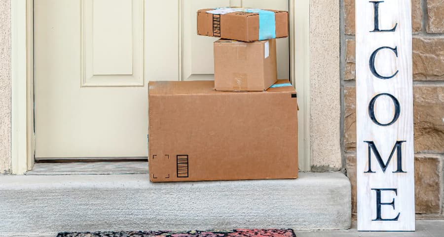 Packages on the doorstep of a home with a welcome sign in Burlington